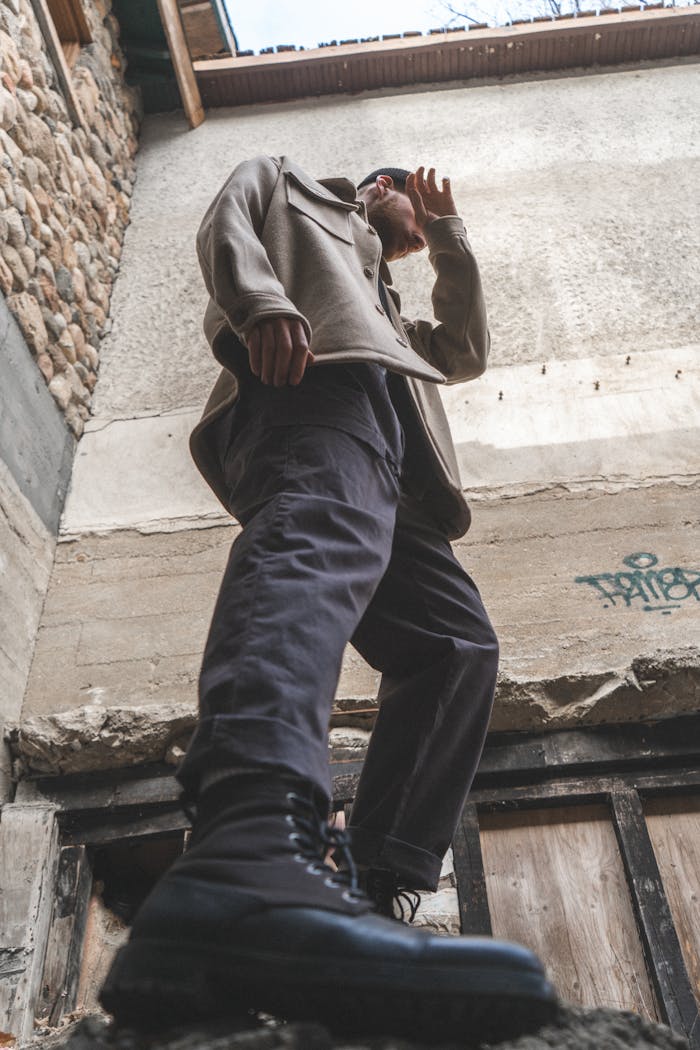 about-us-02 Dynamic low angle shot of a man in boots and coat standing outdoors against a building in Ottawa.
